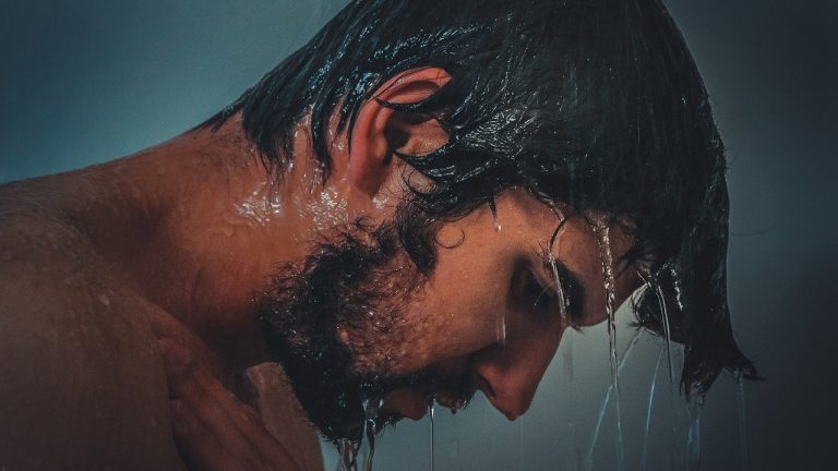 mężczyzna z brodą pod prysznicem